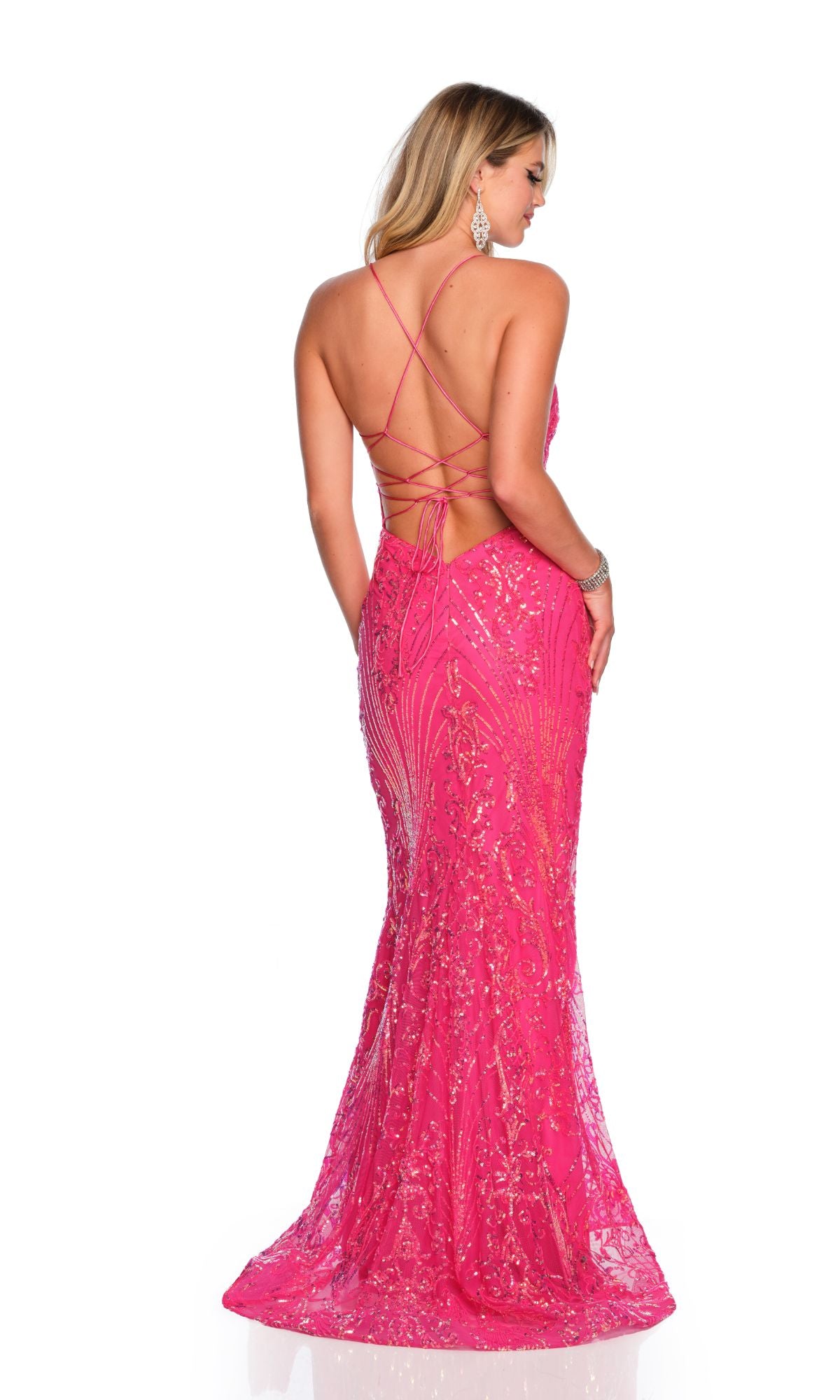 A woman stands facing away in the Long Formal Dress 11492 by Dave and Johnny, a bright pink, fitted, floor-length sequin gown with an open lace-up back and crisscross straps.